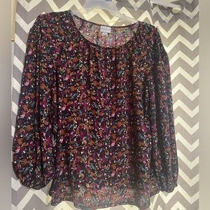 Women’s flowered blouse with cinched long sleeves.